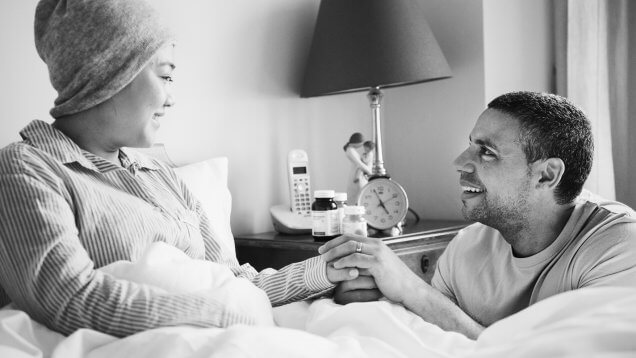 A sick woman in bed with her partner